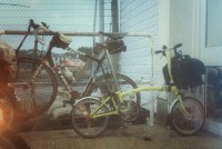 Yellow fold-up bike parked in front of full-size road machine