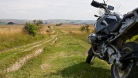 Motorcycle parked at the start of a rutted trail in rural England